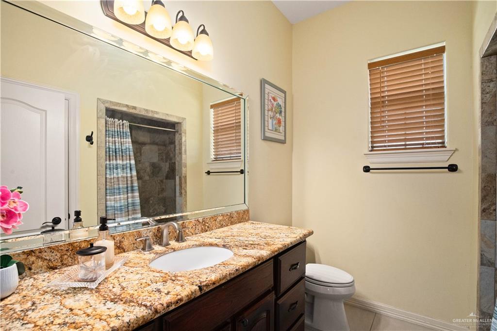 917 Beddoes Road La Feria, TX 78559 - Photo 13 of 20 a bathroom with a granite countertop sink toilet and mirror