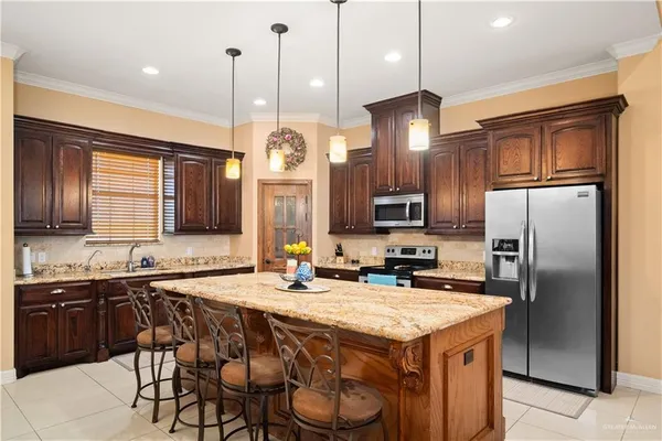 a kitchen with a refrigerator a sink and chairs