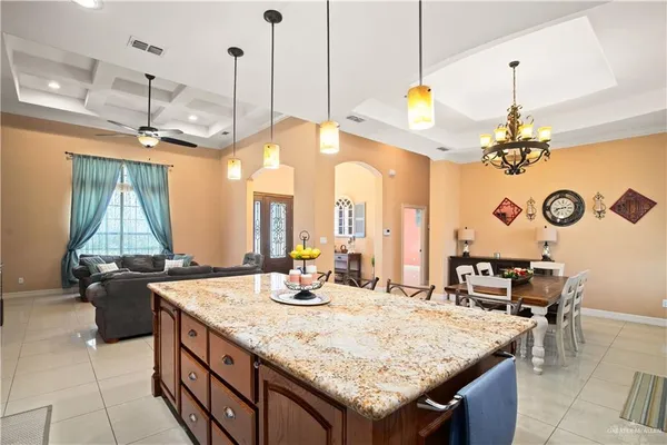 a room with kitchen island granite countertop a sink a counter top space and living room view