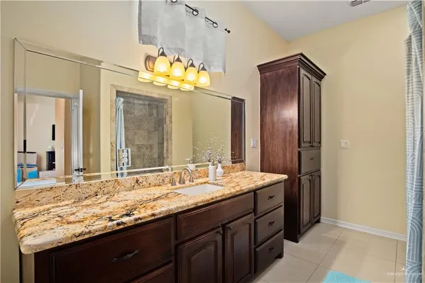 a bathroom with a granite countertop sink and a mirror