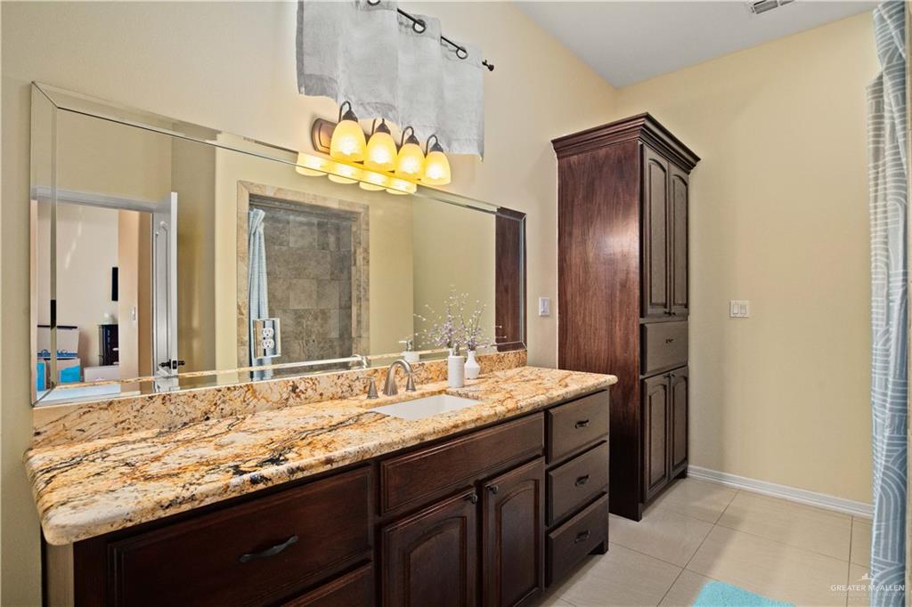 917 Beddoes Road La Feria, TX 78559 - Photo 9 of 20 a bathroom with a granite countertop sink and a mirror