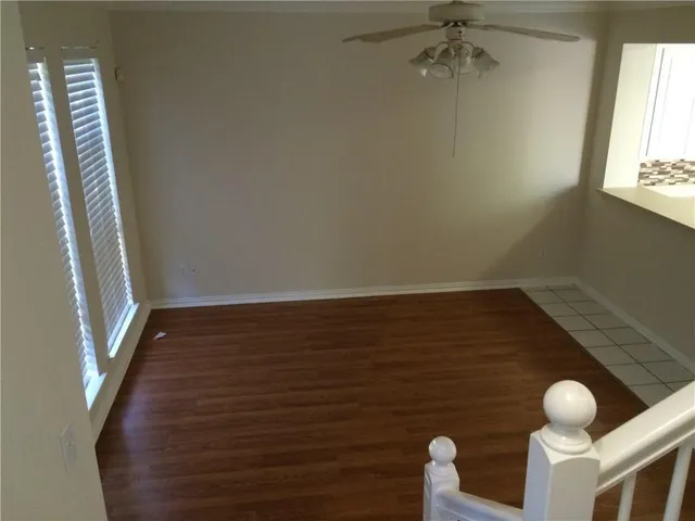 a view of a livingroom with wooden floor and stairs