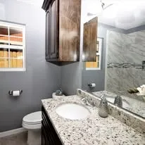 a bathroom with a granite countertop sink and a toilet