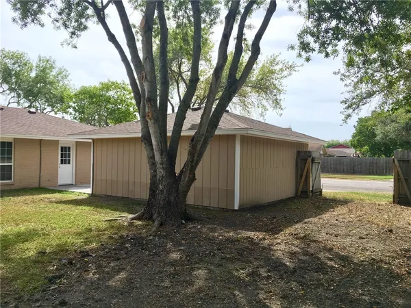 a view of a house with backyard and a tree