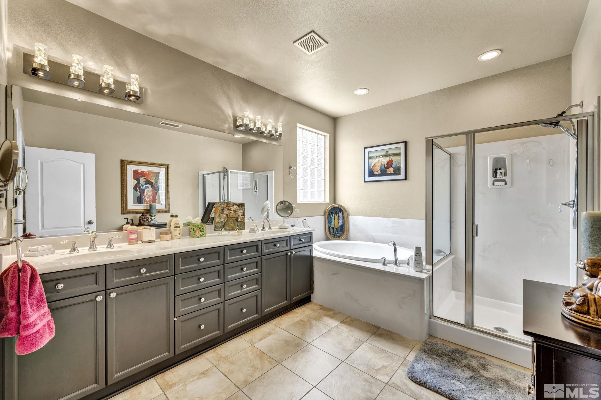 2199 Angel Ridge Drive Reno, NV 89521 - Photo 20 of 36 a bathroom with a tub a double vanity sink and a mirror