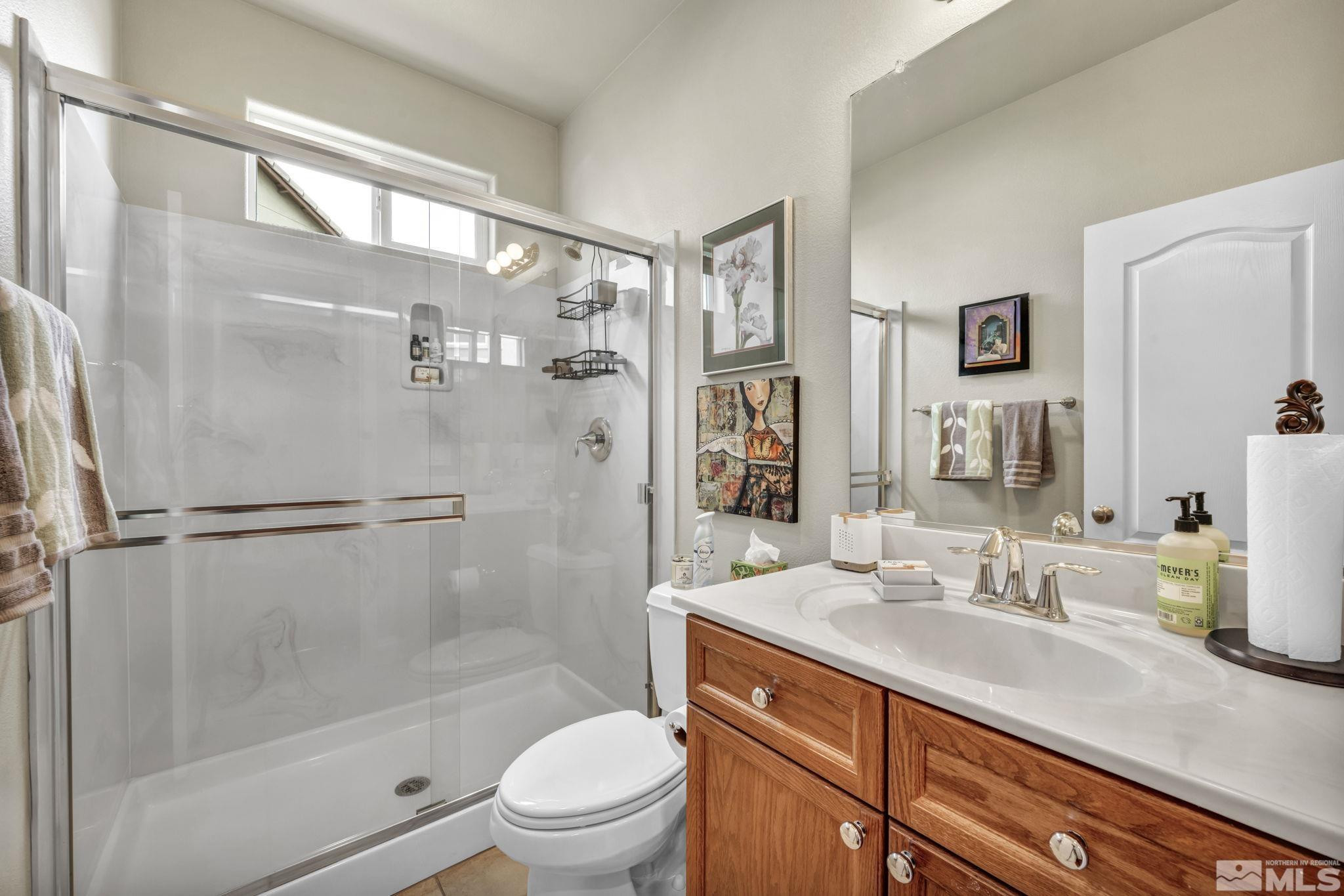 2199 Angel Ridge Drive Reno, NV 89521 - Photo 29 of 36 a bathroom with a shower sink vanity mirror and toilet