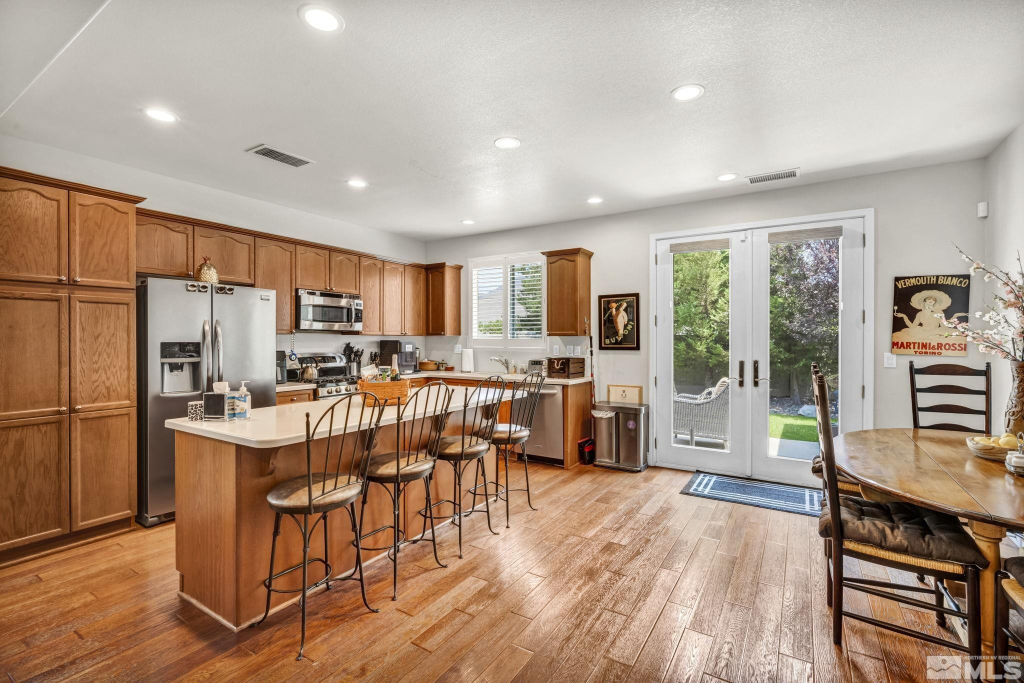 2199 Angel Ridge Drive Reno, NV 89521 - Photo 3 of 36 a kitchen with stainless steel appliances a stove a refrigerator a kitchen island furniture and wooden floor