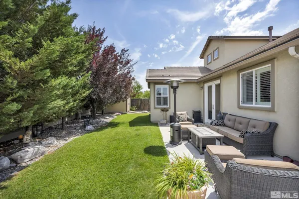a view of a house with backyard and sitting area