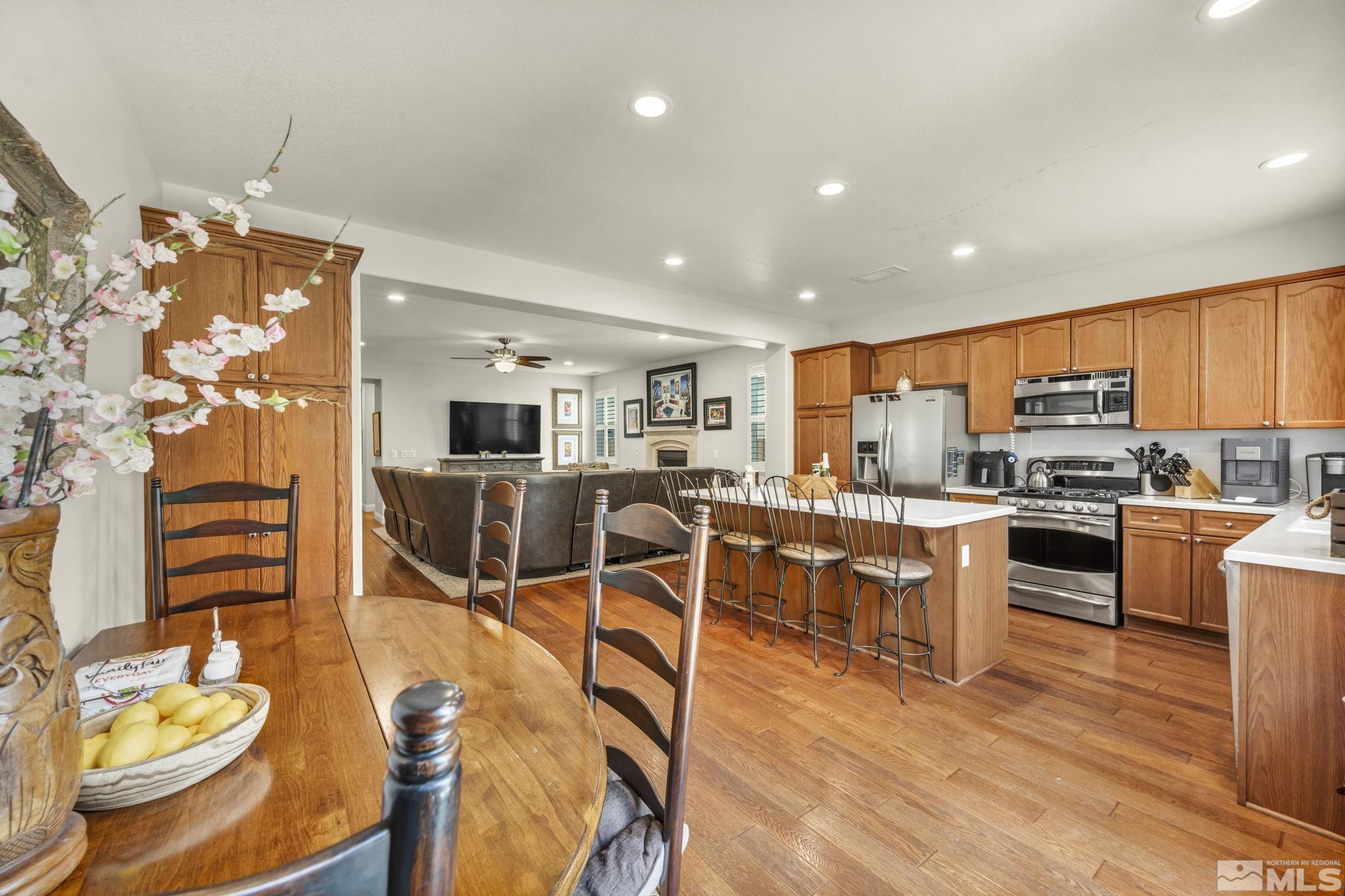 2199 Angel Ridge Drive Reno, NV 89521 - Photo 6 of 36 a kitchen with stainless steel appliances kitchen island granite countertop a stove a sink a microwave a dining table and chairs