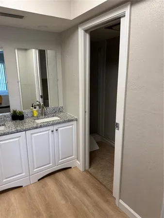 a bathroom with a granite countertop sink and a mirror