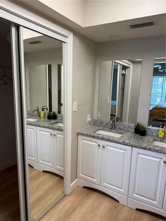 a bathroom with a granite countertop sink and a mirror
