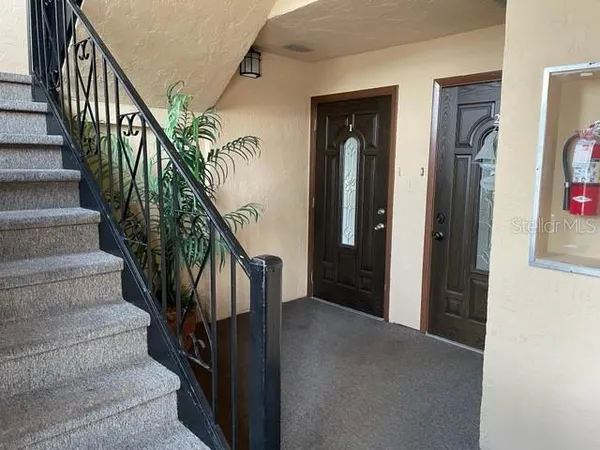a view of staircase with lots of frames on wall and stairs