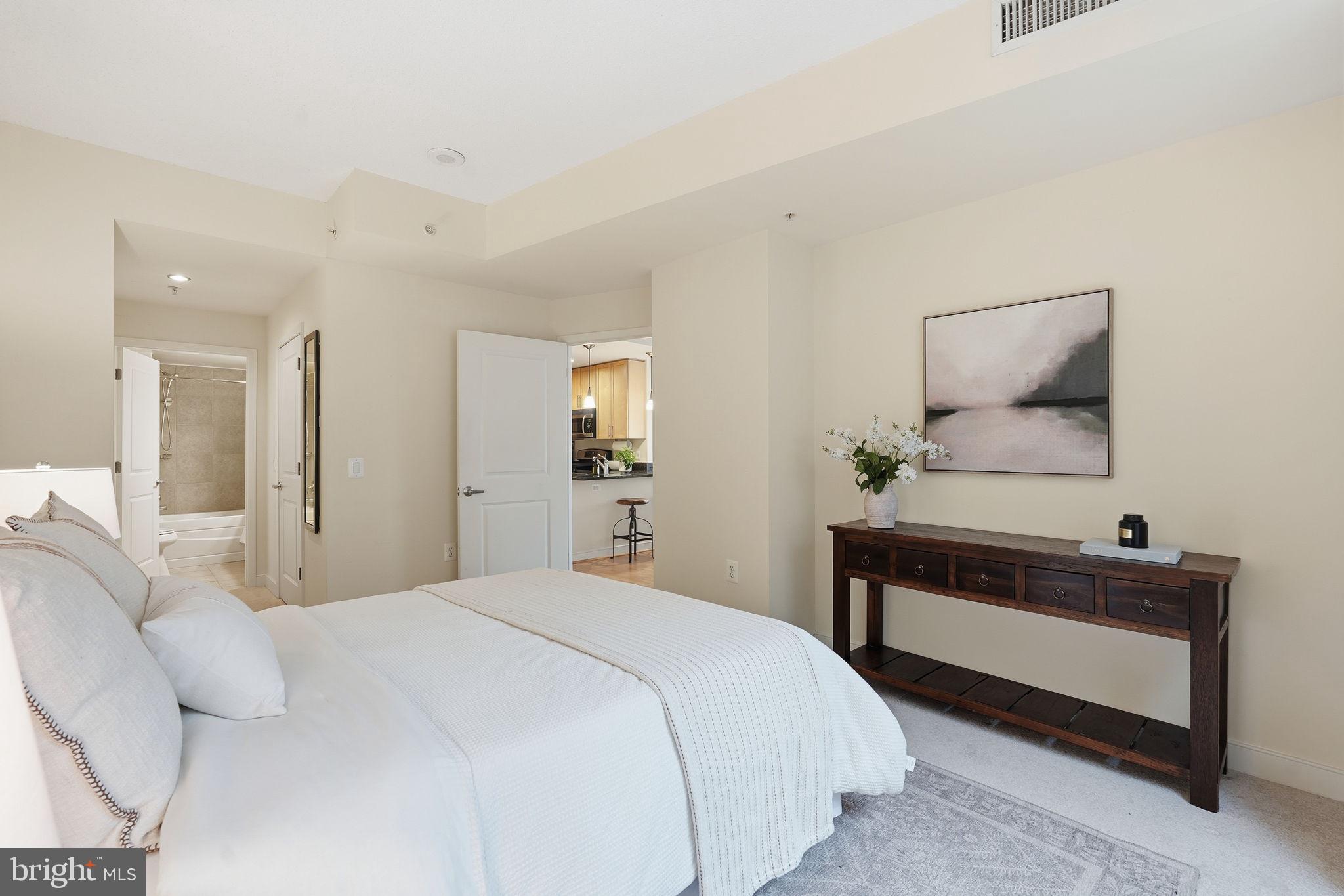 820 North Pollard Street, Unit 504 Arlington, VA 22203 - Photo 14 of 27 a bedroom with a bed and a lamp on dresser