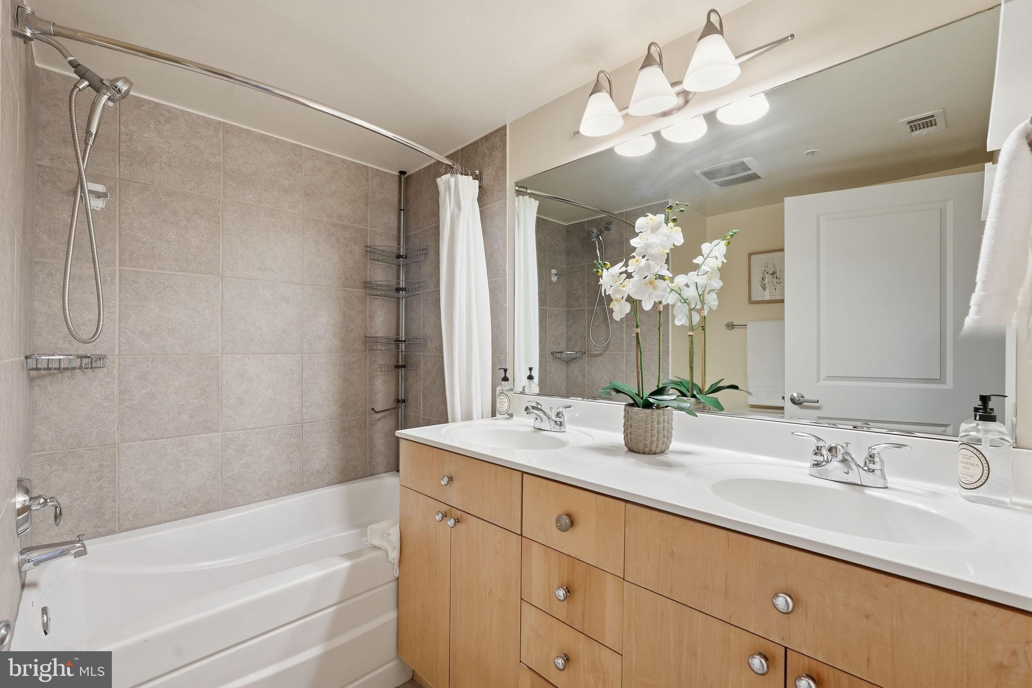 820 North Pollard Street, Unit 504 Arlington, VA 22203 - Photo 17 of 27 a bathroom with a double vanity sink mirror and shower