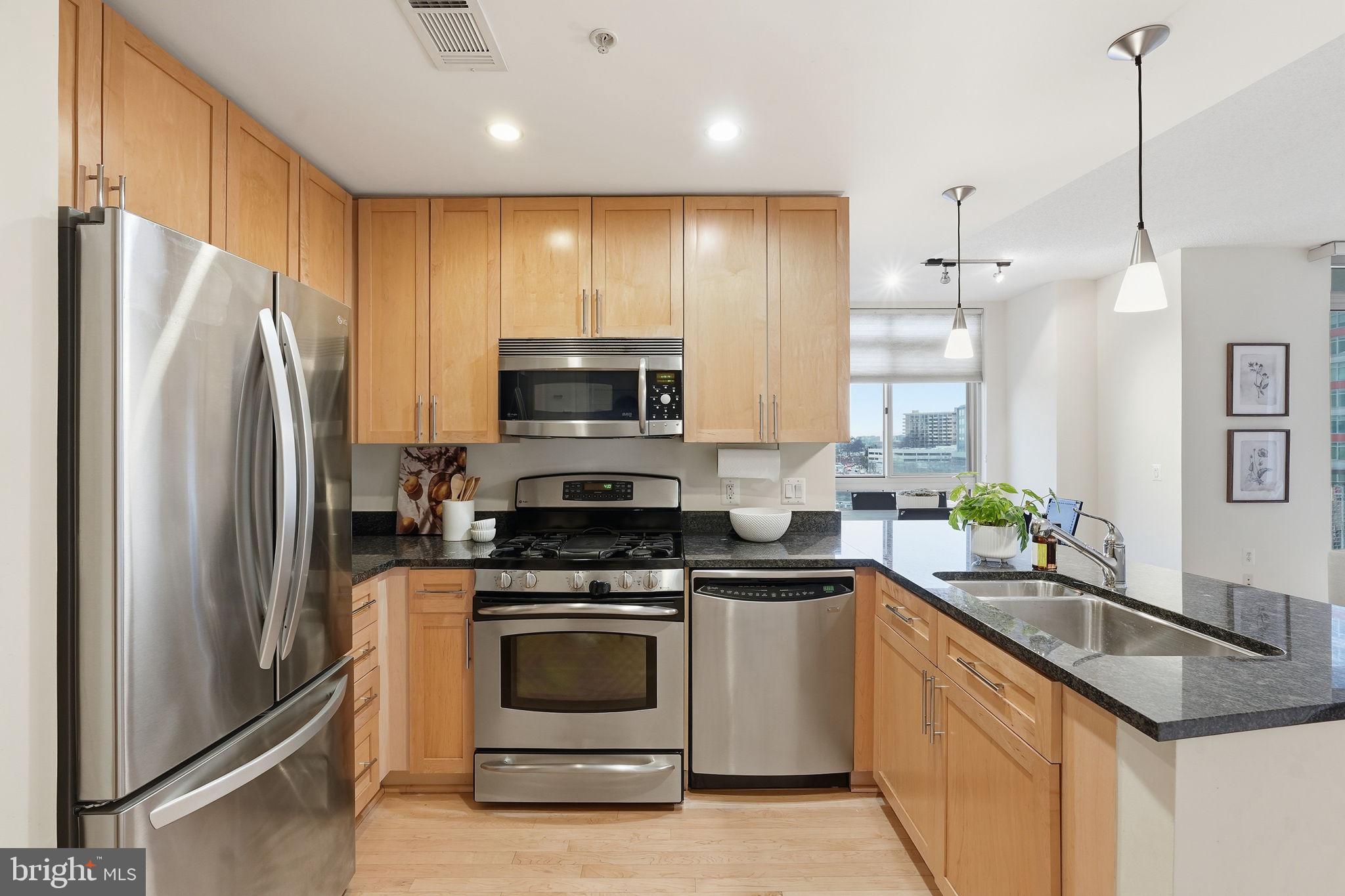 820 North Pollard Street, Unit 504 Arlington, VA 22203 - Photo 3 of 27 a kitchen with stainless steel appliances a stove a sink a refrigerator a window and white cabinets