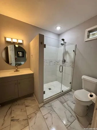 a bathroom with a sink a toilet and shower