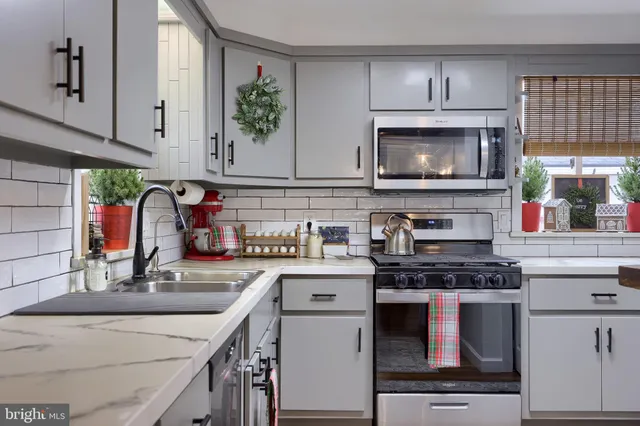 a kitchen with stainless steel appliances a stove sink and cabinets