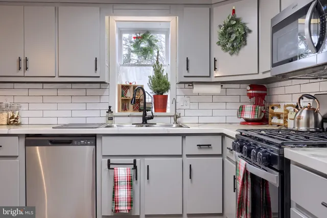 a kitchen with stainless steel appliances granite countertop a sink stove and cabinets