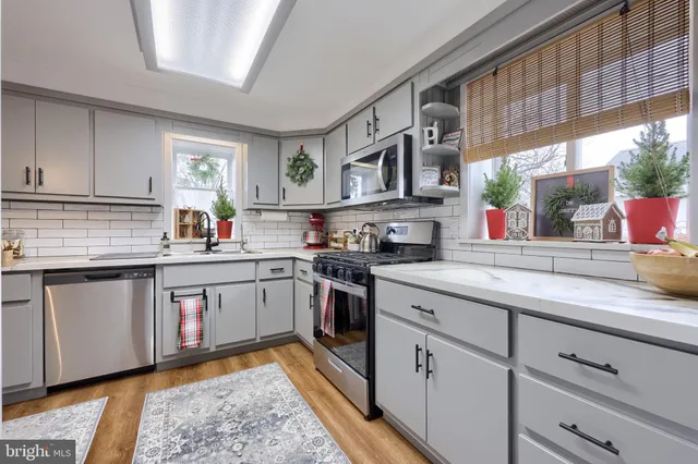 a kitchen with stainless steel appliances granite countertop a sink and cabinets