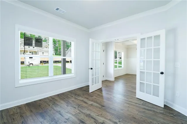 an empty room with wooden floor and windows