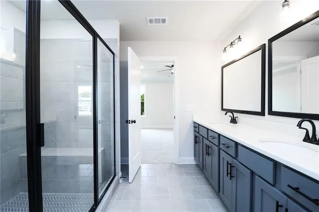 a bathroom with a double vanity sink and mirror with shower