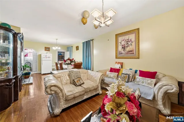 a living room with furniture flowerpot and a chandelier