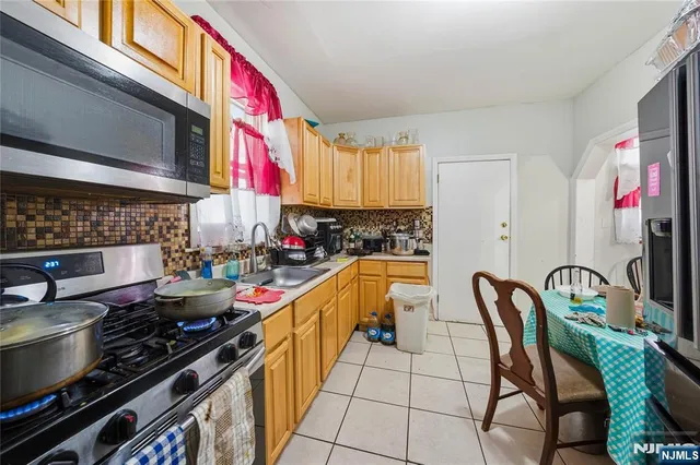 a kitchen with stainless steel appliances granite countertop a stove and a dining table