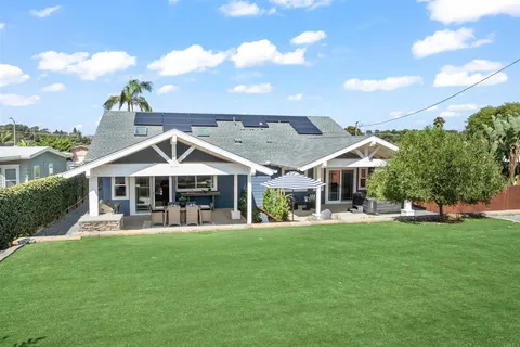 a view of a house with a big yard and potted plants
