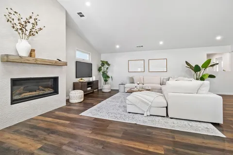 a living room with furniture a fireplace and a chandelier