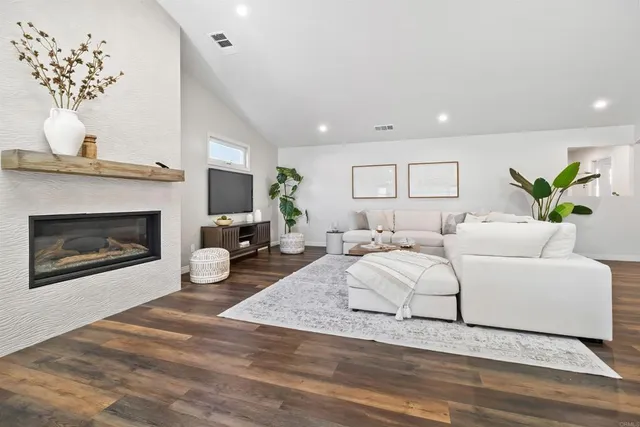 a living room with furniture a fireplace and a chandelier