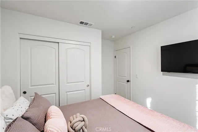 a bedroom with a bed and a flat screen tv