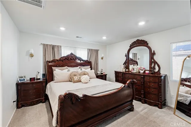 a bedroom with a bed and a dresser with mirror