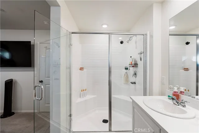a bathroom with a shower sink and mirror