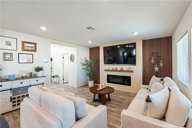 a living room with furniture a fireplace and a flat screen tv