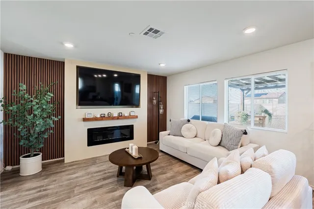 a living room with furniture a flat screen tv and a fireplace