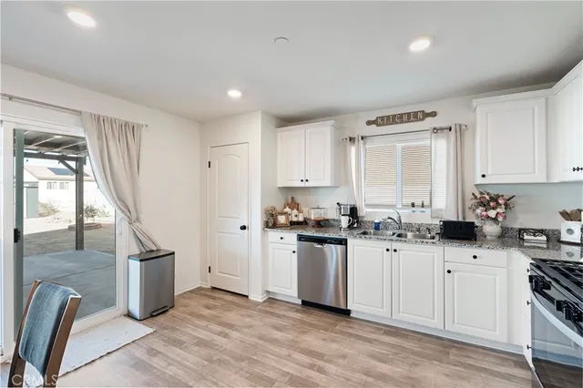 a kitchen with granite countertop a sink appliances and cabinets