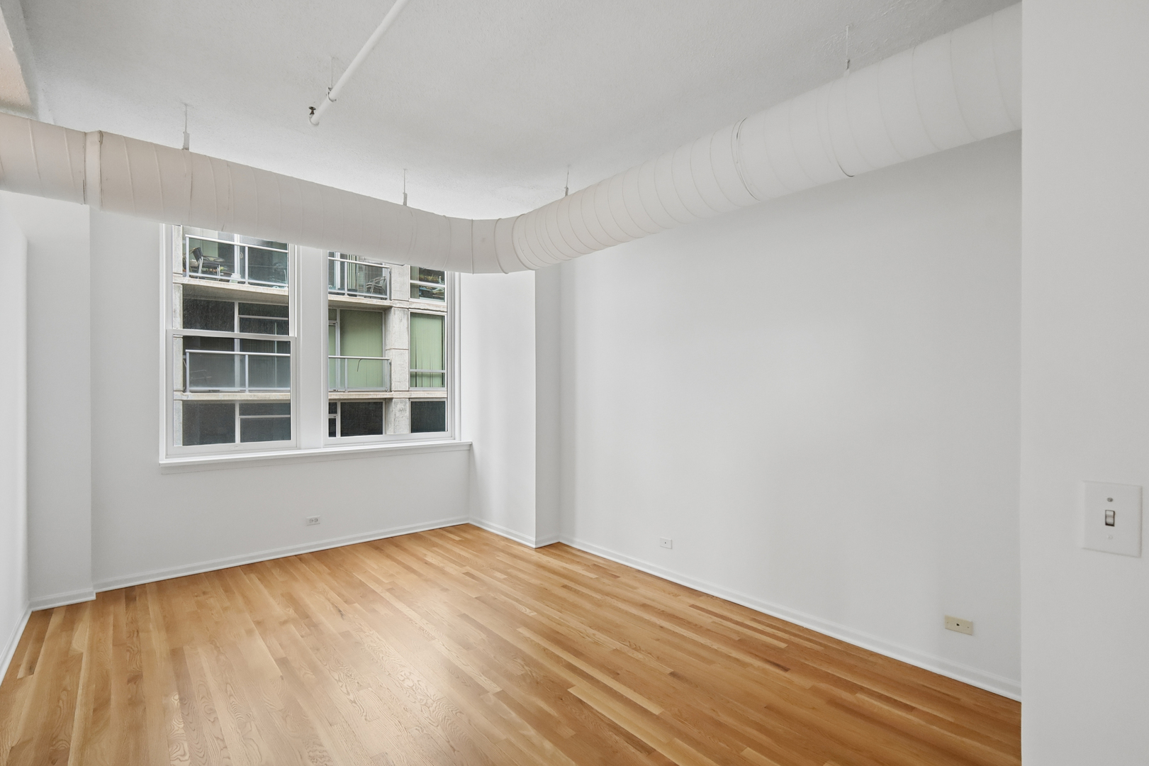161 West Harrison Street, Unit 1007 Chicago, IL 60605 - Photo 15 of 35 a view of an empty room with wooden floor and windows