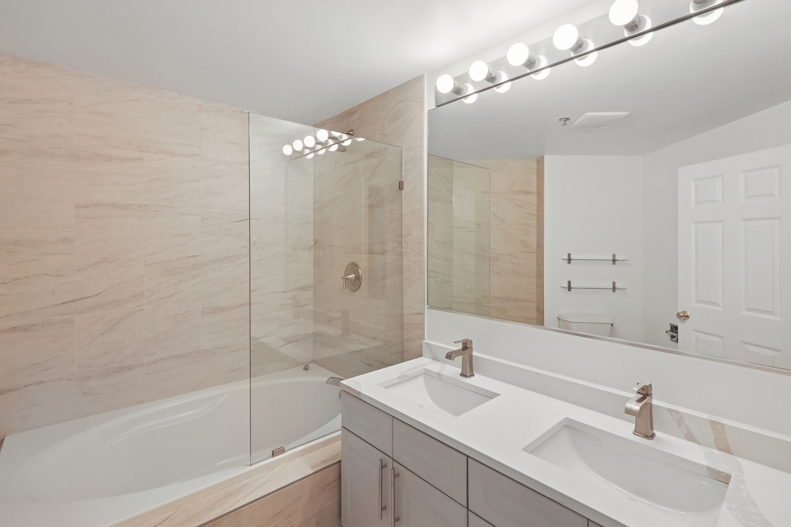 161 West Harrison Street, Unit 1007 Chicago, IL 60605 - Photo 20 of 35 a bathroom with a sink double vanity granite tub shower and a mirror