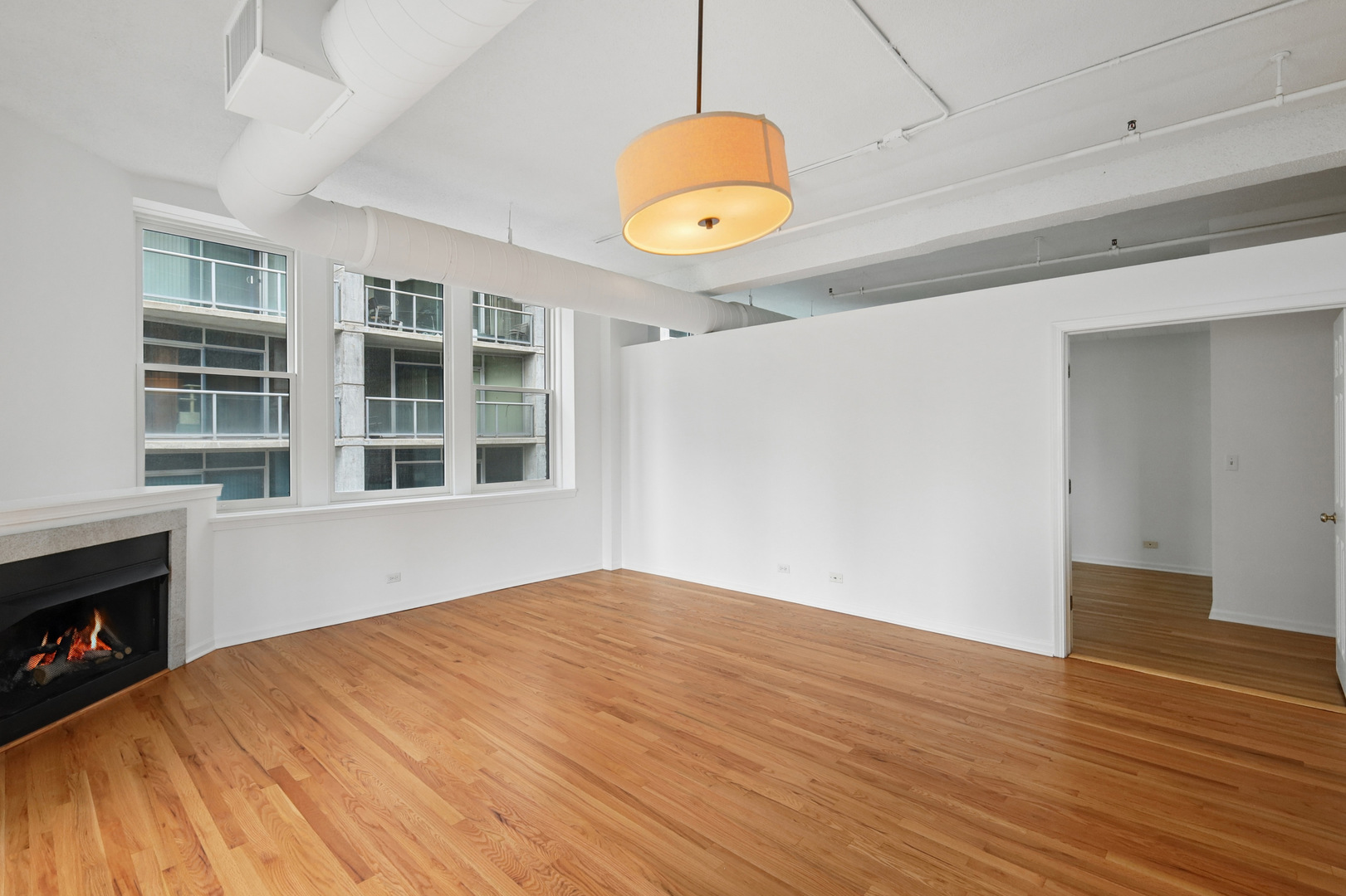 161 West Harrison Street, Unit 1007 Chicago, IL 60605 - Photo 5 of 35 a view of an empty room with wooden floor and a window