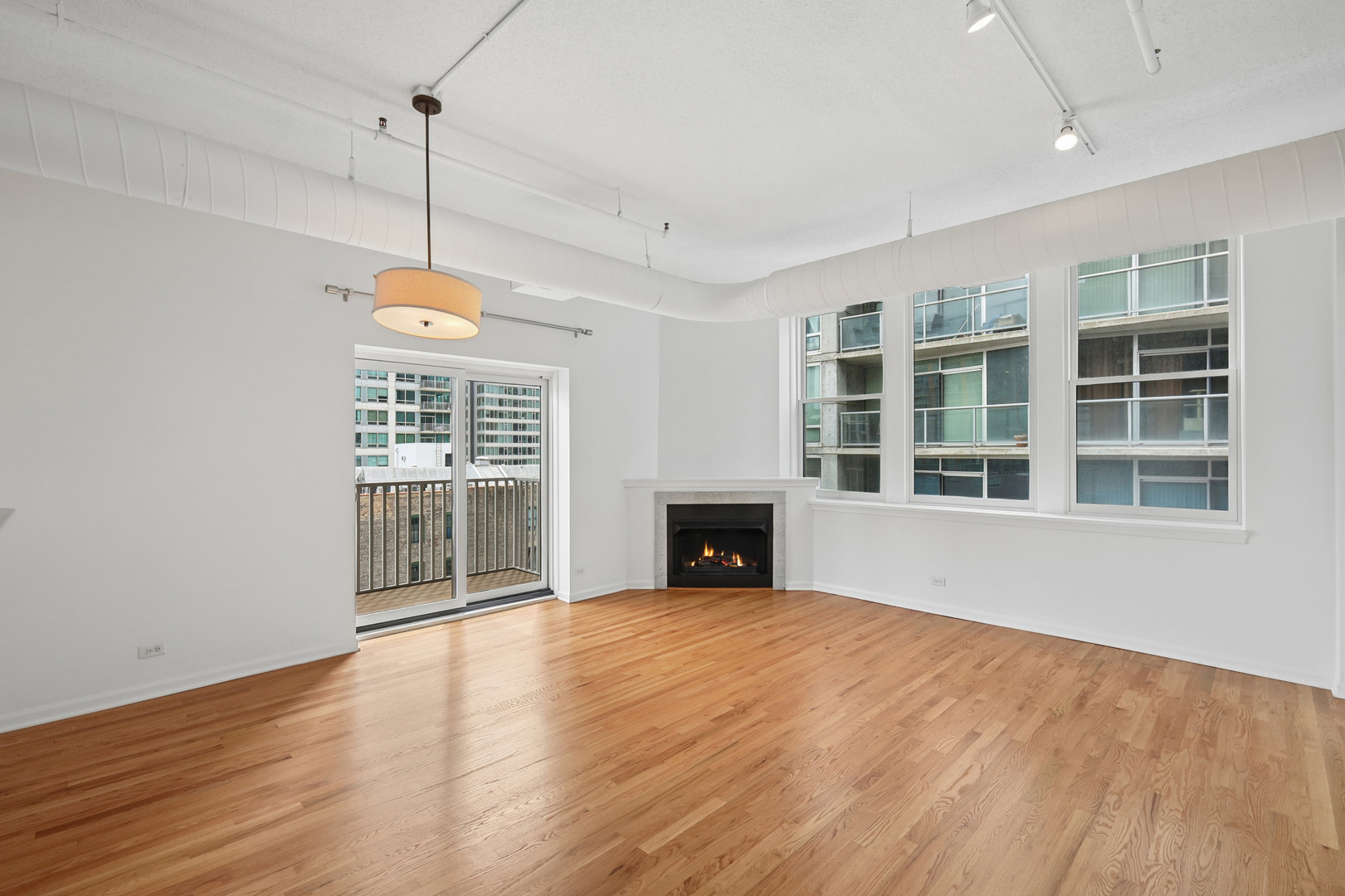 161 West Harrison Street, Unit 1007 Chicago, IL 60605 - Photo 7 of 35 a view of an empty room with wooden floor fireplace and a window