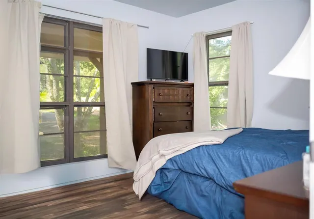 a bedroom with a bed and a flat tv screen on dresser