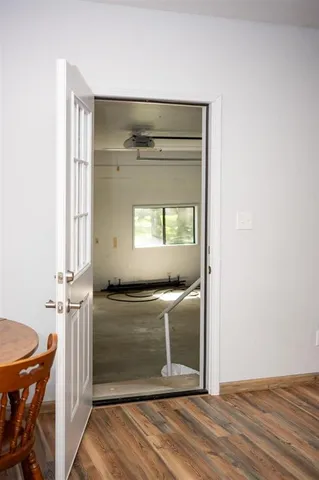 a view of a hallway with wooden floor and chair