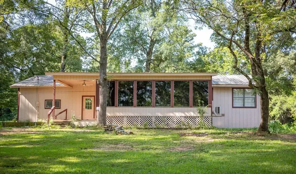 a view of a house with garden and trees