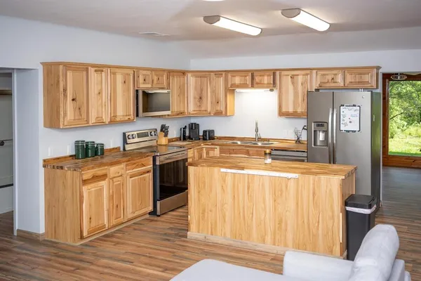 a kitchen with stainless steel appliances granite countertop a stove a sink dishwasher and a refrigerator