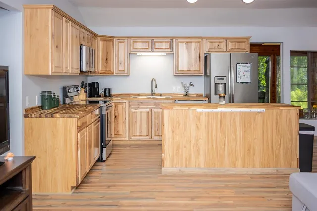 a kitchen with stainless steel appliances granite countertop a stove a sink and a refrigerator