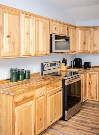 a kitchen with stainless steel appliances granite countertop a stove a sink and a microwave