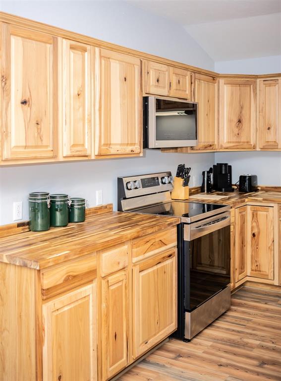523 Big Lake Road Karnack, TX 75661 - Photo 7 of 27 a kitchen with stainless steel appliances granite countertop a stove a sink and a microwave
