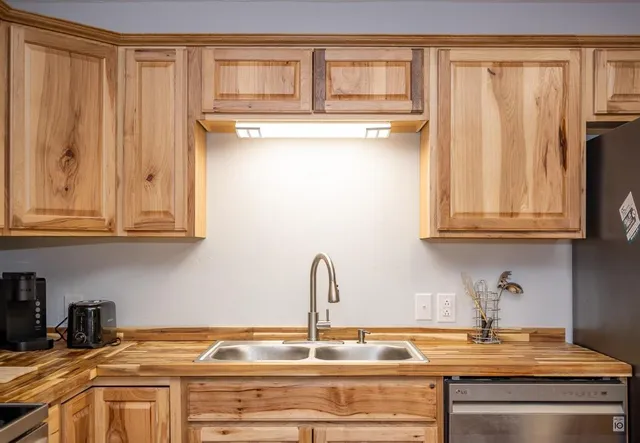 a kitchen with stainless steel appliances granite countertop a refrigerator and a sink