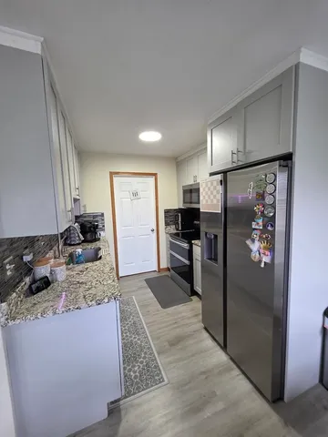 a kitchen with stainless steel appliances granite countertop a refrigerator and a sink