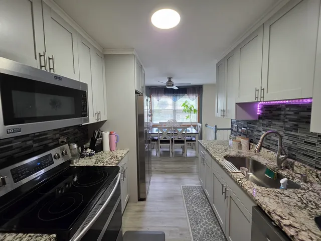 a kitchen with stainless steel appliances a stove sink microwave and cabinets